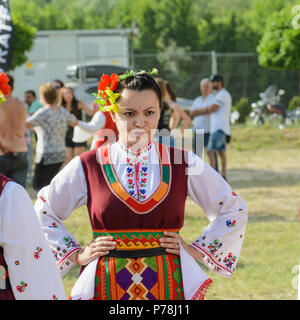 Varna, Bulgarien - 10. Juni 2018: Menschen in authentische Folklore Kostüm in einer Wiese tanzen Bulgarischen traditionellen Tanz namens Horo Stockfoto