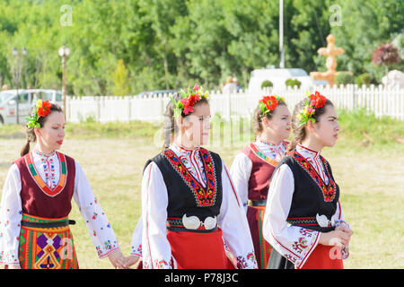 Varna, Bulgarien - 10. Juni 2018: Menschen in authentische Folklore Kostüm in einer Wiese tanzen Bulgarischen traditionellen Tanz namens Horo Stockfoto