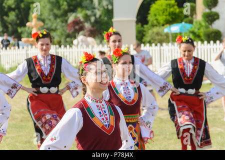 Varna, Bulgarien - 10. Juni 2018: Menschen in authentische Folklore Kostüm in einer Wiese tanzen Bulgarischen traditionellen Tanz namens Horo Stockfoto