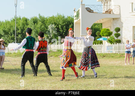 Varna, Bulgarien - 10. Juni 2018: Menschen in authentische Folklore Kostüm in einer Wiese tanzen Bulgarischen traditionellen Tanz namens Horo Stockfoto