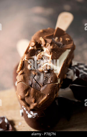 Nahaufnahme von etwas Schokolade Eis Balken auf einem Schneidebrett, auf einem rustikalen Holztisch gelegt Stockfoto