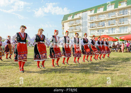 Varna, Bulgarien - 10. Juni 2018: Menschen in authentische Folklore Kostüm in einer Wiese tanzen Bulgarischen traditionellen Tanz namens Horo Stockfoto