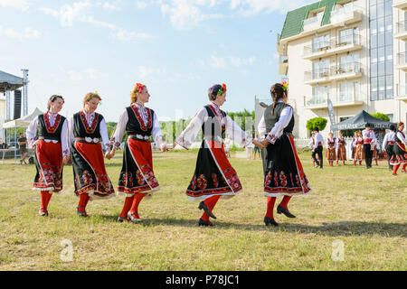 Varna, Bulgarien - 10. Juni 2018: Menschen in authentische Folklore Kostüm in einer Wiese tanzen Bulgarischen traditionellen Tanz namens Horo Stockfoto