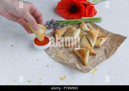 Hand dip Griescreme pie in Tomatensoße Stockfoto