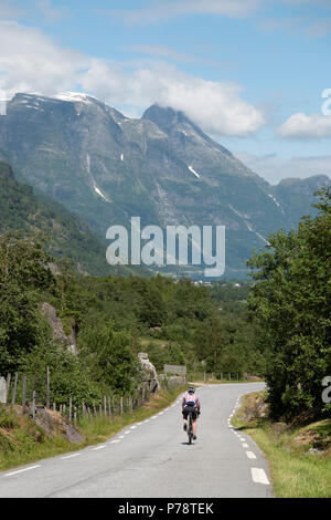 Weibliche Radfahrer auf der Valley Road über Olden, Norwegen Stockfoto