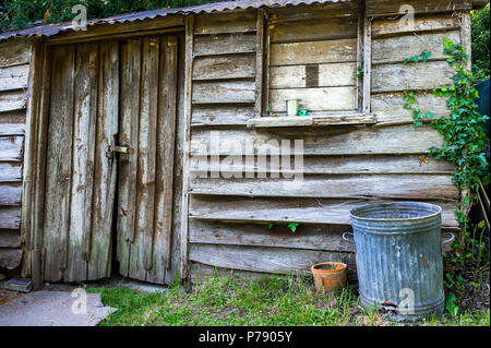 Alte Eiche Gartenhaus und verzinktem Mülleimer. Stockfoto