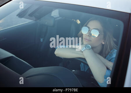 Junge attraktive Frau, die ihr Auto. Porträt einer erfolgreichen Geschäftsfrau, lässigen Stil Stockfoto