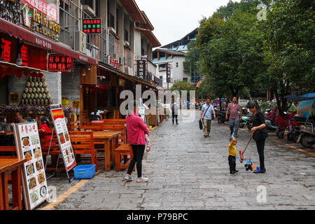 YANGSHUO, CHINA - 10. MAI 2018: Einkaufsstraße mit Restaurants und Gaststätten in der Nähe des Marktes in der Innenstadt von der Stadt Guilin, Guangxi, China. Frieden fa Stockfoto