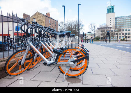 Eine Reihe von Mobike sharing Fahrräder auf John Dobson Straße, Newcastle upon Tyne Newcastle geparkt, mit dem Civic Center im Hintergrund Stockfoto