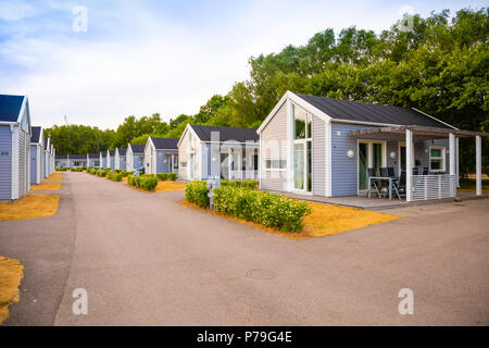 Raa, Schweden - 17.06.2018: Gruppe von ähnlichen grauen Camping Hütten in kleinen schwedischen Stadt Raa Stockfoto