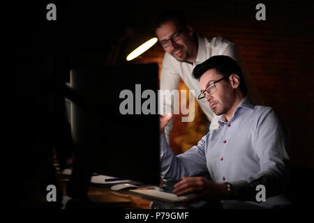Geschäftsmann mit Dokumenten arbeiten dunklen Büro Stockfoto