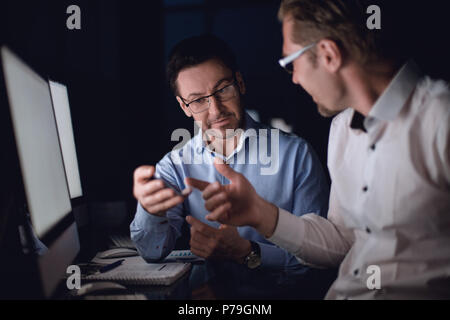 Bis zu schließen. Zwei business Männer an den Bildschirm des Smartphones. Stockfoto