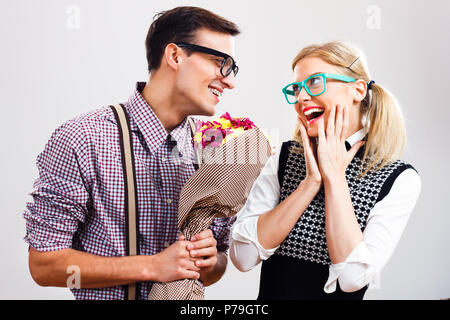 Nerdy Mann ist, die Blumen in seinem nerdy Dame. Stockfoto