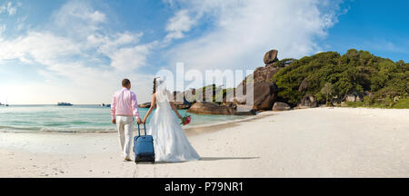 Happy neu verheiratete Paare in den Flitterwochen, die auf Sun Sandstrand in Thailand Stockfoto