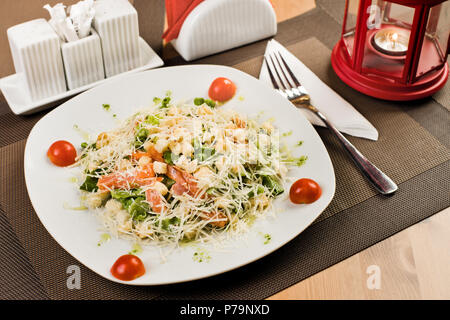 Keramik weiße Platte mit Salat, am Tisch im Restaurant Stockfoto