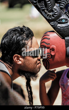 Maori Mann führt hongi mit der Vorderseite des Ngātokimatawhaorua zeremoniellen Krieg Kanu (Waka Taua) am Waitangi Treaty Grounds in Neuseeland Stockfoto