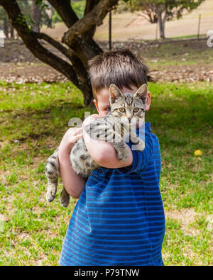 Kleiner Junge Holding eine Katze in seine Arme. Stockfoto