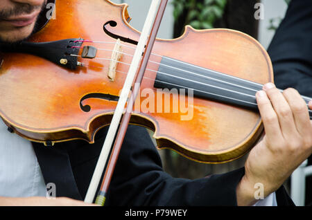 Kunst und Künstler. Junge eleganten Mann Geiger spielen Geige auf Schwarz. Klassische Musik. kleiner Junge Musikinstrument. Stockfoto