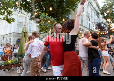 Lemberg, Ukraine - Juni 9, 2018: Salsa Tänzer in Café im Freien in der Nähe von Diana Brunnen am Marktplatz in Lemberg. Jugendliche Salsa tanzen. Stockfoto