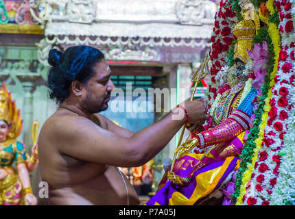 Indischer Mann schmückt Idol im Tempel von Sri Veeramakaliamman in Little India, Singapur Stockfoto