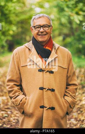Outdoor Portrait von Happy älterer Mann mit Mantel im Herbst. Stockfoto
