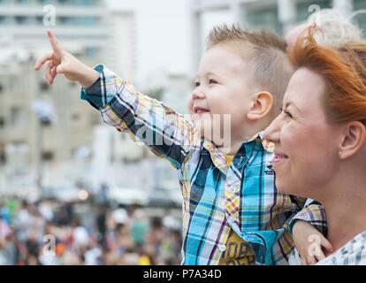 Adorable Kind und seine Mutter gerade die Air Show zu Israels Unabhängigkeitstag in der Promenade von Tel Aviv gewidmet. Yom Ha'Atzmaut stock Bild. Stockfoto