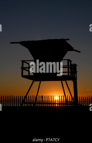 Rettungstürme mit Sonnenuntergang Huntington Beach Kalifornien Silhouette Stockfoto