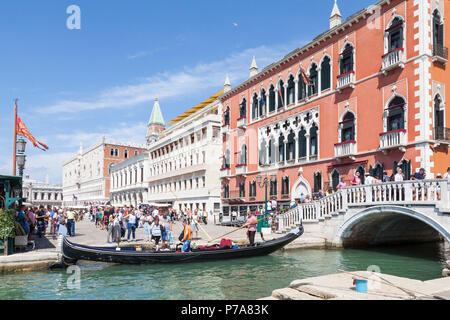 Touristen aussteigen aus Gondeln in Rio del Vin im Hotel Danieli, Castello, Venedig, Venetien, Italien. Blick entlang der Riva degli Schiavonni zu Dogen Stockfoto