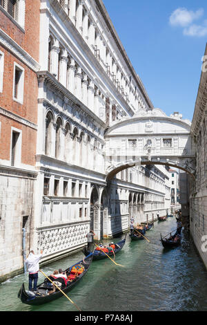 Gondeln mit Touristen rudern unter der Seufzerbrücke (Ponte dei Sospiri), San Marco, Venedig, Venetien, Italien zwischen dem Dogenpalast und venezianischen Stockfoto