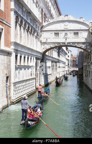 Gondeln mit Touristen rudern unter der Seufzerbrücke (Ponte dei Sospiri), San Marco, Venedig, Venetien, Italien zwischen dem Dogenpalast und venezianischen Stockfoto