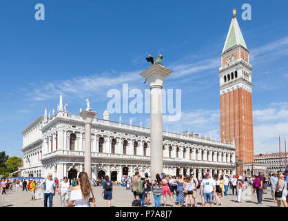 Touristische Menschenmenge vor der Marciana Bibliothek im Piazetta San Marco, Venedig, Venetien, Italien mit dem Glockenturm (Campanile) und zwei Spalten Stockfoto