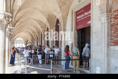 Lange Schlange von Touristen warten, um den Dogenpalast, den Palazzo Ducale, Palazzo Ducale in San Marco, Venedig, Venetien, Italien Queuing unter den Arkaden o eingeben Stockfoto