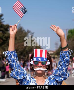 Los Angeles, USA. 4. Juli 2018. Ein Teilnehmer das Tragen einer Maske Wellen auf die Masse, wenn in der jährlichen 4. Juli Parade in South Pasadena, Kalifornien, USA, am 4. Juli 2018 marschieren. Credit: Zhao Hanrong/Xinhua/Alamy leben Nachrichten Stockfoto