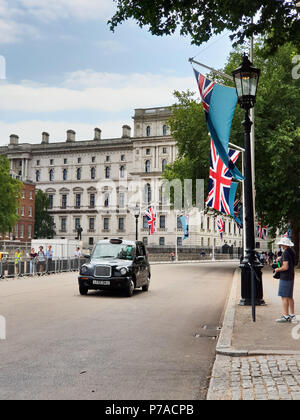 Horse Guards Parade. London. UK vom 4. Juli 2018 - einen schwarzen Londoner Taxi fährt vorbei an der Anzeige der Royal Air Force und Union Jack Fahnen entlang der Mall, das 100-jährige Jubiläum der Royal Air Force auf Horse Guards Parade in Westminster, London. Kredit Roamwithrakhee/Alamy leben Nachrichten Stockfoto