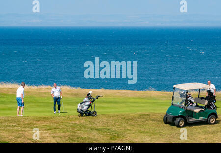 North Berwick, East Lothian, Schottland, Vereinigtes Königreich, 5. Juli 2018. Golfspieler mit einem Golfbuggy spielen auf Glen Golf neben dem Firth von weiter Stockfoto