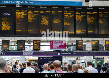 London, Großbritannien. 5. Juli 2018. Fahrgäste warten Züge am Bahnhof Victoria vor einem Board zeigt Züge verzögert nach einem Problem mit Signalanlagen in Streatham im Südosten von London, die gestern Abend entdeckt wurde. Nach Angaben von Network Rail zahlen, Victoria ist Großbritanniens zweite verkehrsreichsten Bahnhof mit 75,8 Mio. Pkw- und Ausfahrten im Jahr. Dienstleistungen auf der Gatwick Express, Thameslink und Südlichen Züge haben durch die Signalisierung Problem betroffen zu sein, mit vielen Annullierungen und Verspätungen. Credit: Mark Kerrison/Alamy leben Nachrichten Stockfoto