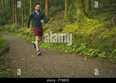 Man joggen in üppiger Wald Stockfoto