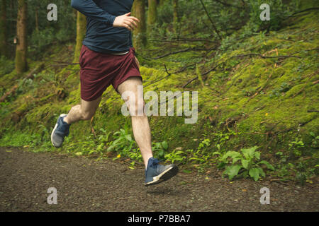 Man joggen in üppiger Wald Stockfoto