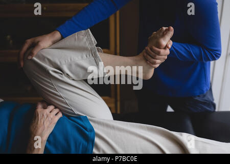 Physiotherapeuten unterstützen eine ältere Frau mit physiotherapeutischen Übungen Stockfoto