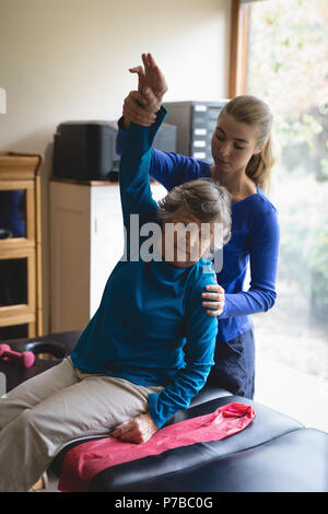 Physiotherapeuten unterstützen eine ältere Frau mit physiotherapeutischen Übungen Stockfoto