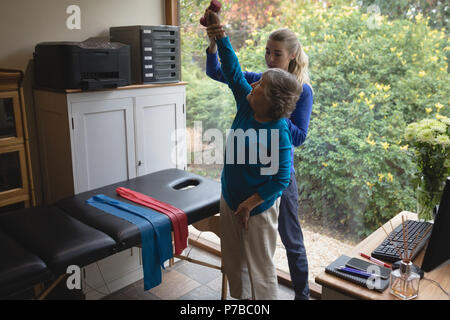 Physiotherapeuten unterstützen eine ältere Frau mit physiotherapeutischen Übungen Stockfoto