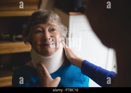 Physiotherapeut Einstellung zervikalen Kragen auf älterer Frau Stockfoto