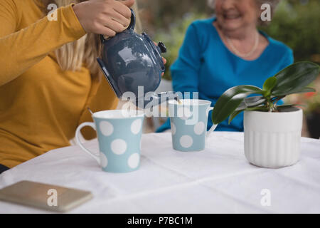 Enkelin und Oma in Kaffee Stockfoto
