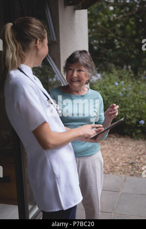 Physiotherapeut und ältere Frau mit einem Tablet Stockfoto