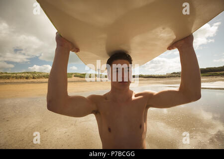 Surfer, die das Surfbrett auf dem Kopf Stockfoto