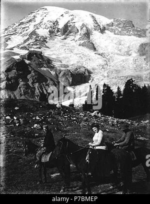 . Englisch: Zwei Männer und eine Frau auf dem Pferd, Mount Rainier National Park, Washington, Ca. 1910. Englisch: Mt. Rainier im Hintergrund. Auf der Hülse der Negativen: Mtn. Menschen und Pferde Themen (LCTGM): Reiten - Washington (State) - Mount Rainier National Park; Pferde - Washington (State) - Mount Rainier National Park Themen (LCSH): Mount Rainier National Park (Washington). Um 1910 81 zwei Männer und eine Frau auf dem Pferd, Mount Rainier National Park, Washington, ca 1910 (BAR108) Stockfoto