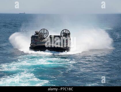 180703-N-XK 809-118 PAZIFISCHEN OZEAN (3. Juli 2018) Landing Craft air cushion (LCAC) 58, zugeordnet zu den Angriff Craft Unit (ACU) 5, Ansätze der gut Deck des Amphibious Assault ship USS BONHOMME RICHARD (LHD6). Bonhomme Richard ist derzeit in den USA 3 Flotte Bereich der Operationen. (U.S. Marine Foto von Mass Communication Specialist 3. Klasse William Sykes) Stockfoto