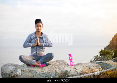Junge Frau in Yoga sitting Pose auf dem Berg Stockfoto