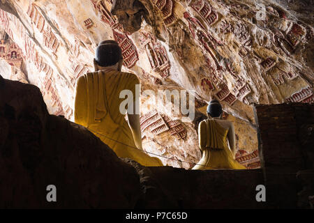 Buddha Statuen von hinten mit Blick auf den geschnitzten Kalkstein Mauer in Kawgun Höhle in der Nähe von Hpa-an, Myanmar, Asien Stockfoto