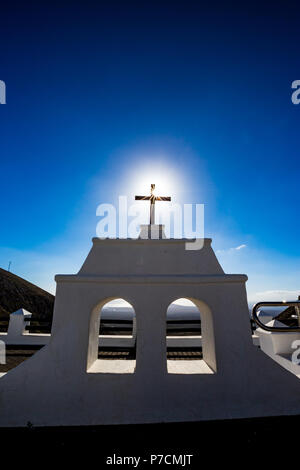 Heiße Sonne durch die berühmte schwarze christliche Kreuz am schönen Ort namens Mirador De Lanzarote auf Lanzarote, Kanarische Inseln, Spanien. Zwei weißen Fenstern und dem klaren, blauen Frühling Himmel Hintergrund Stockfoto